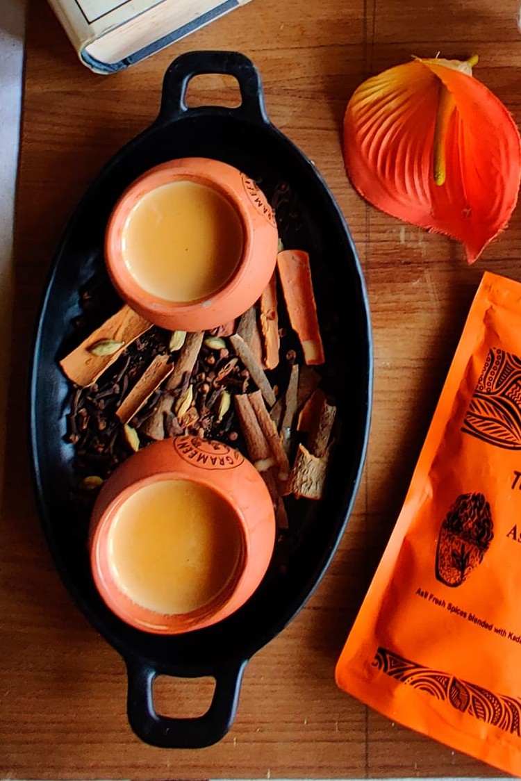Hot cup of chai served beside traditional Bengali snacks.