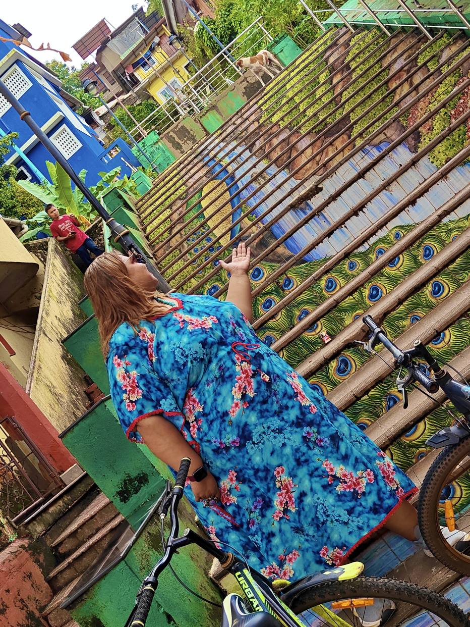 Colorful peacock mosaic staircase in North Goa, with vibrant blue, green, and gold tiles forming a large peacock design along the steps.
