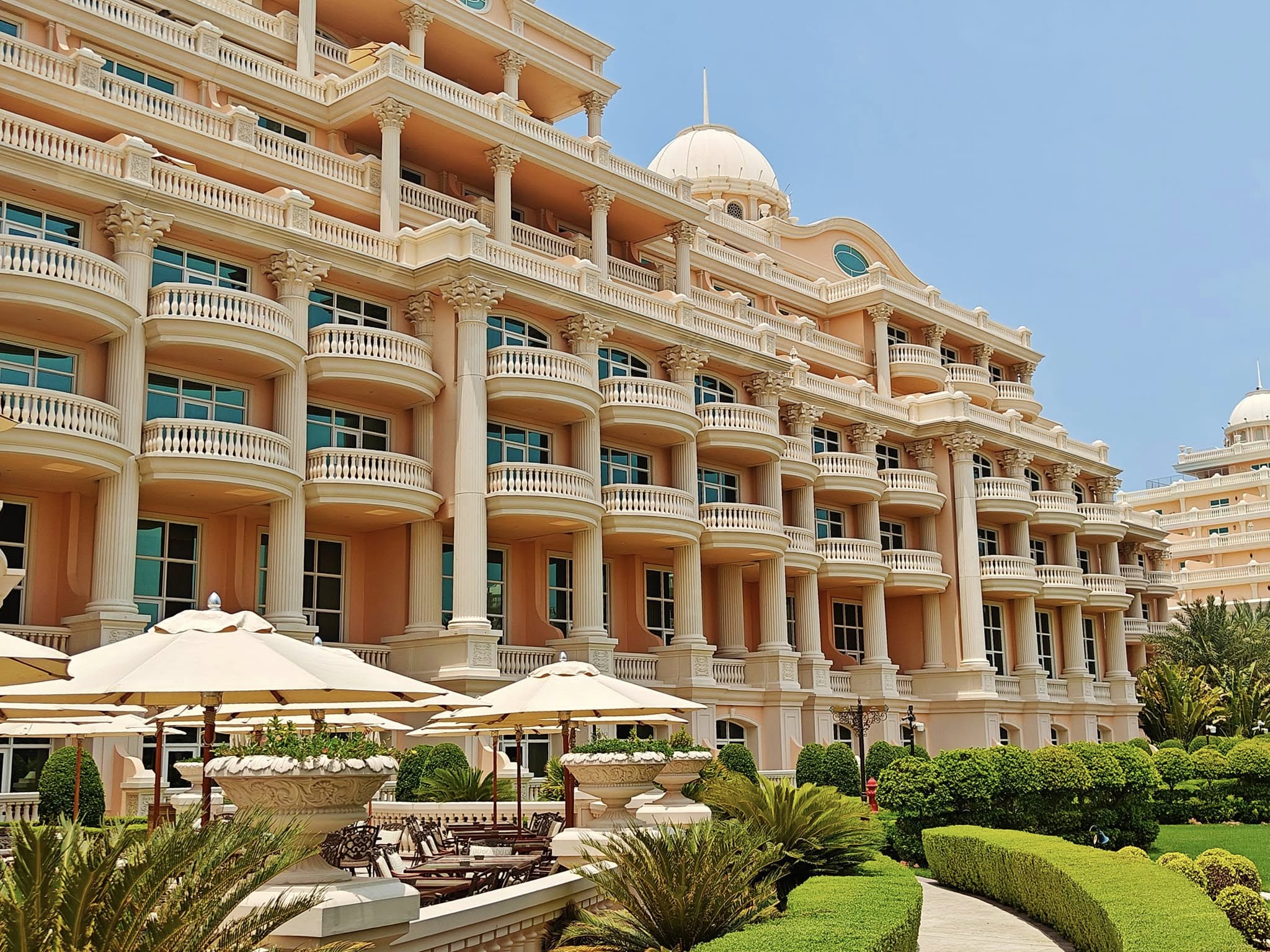 Raffles Hotel on Palm Jumeirah in Dubai, seen from across the water at sunset.