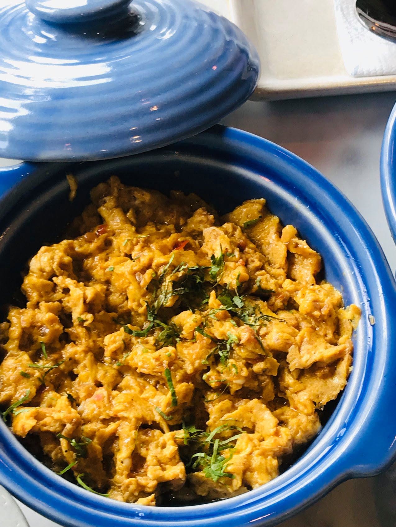 Parsi akuri (spiced scrambled eggs) garnished with fresh coriander, served in a bowl.